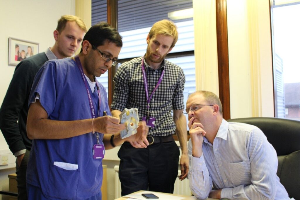 Surgeons examine a 3D printed heart model.
